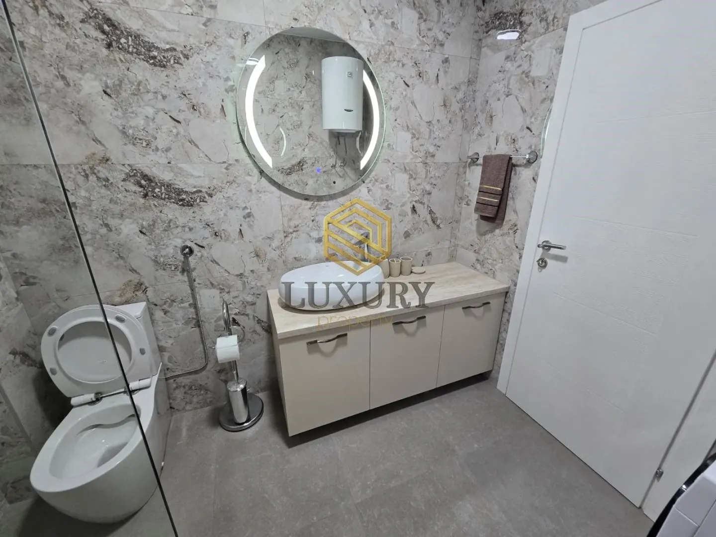 Moderne kupatilo sa umivaonikom, ogledalom i wc šoljom.