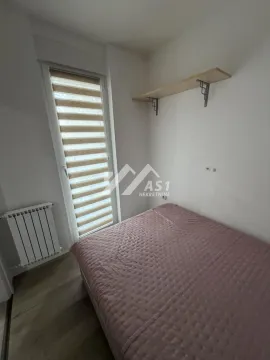 Small bedroom with a bed, window, and wall shelf. - image 6