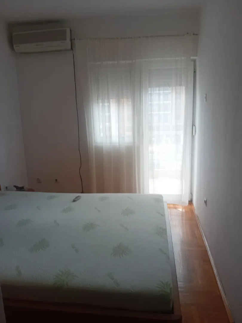 Svijetla spavaća soba sa krevetom i klima uređajem.