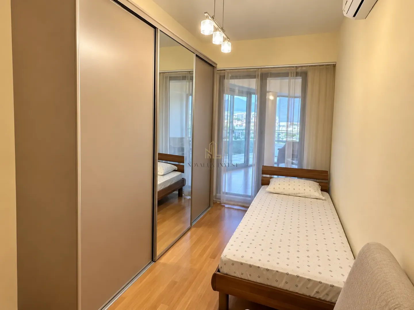 Bedroom with a single bed and a large built-in wardrobe with mirrored doors.