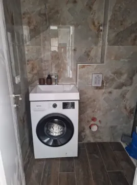 Bathroom with a washbasin and an integrated washing machine. - image 9
