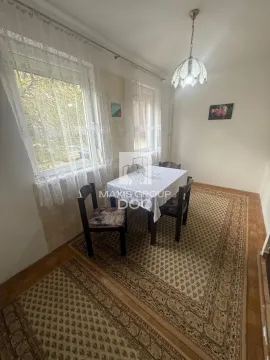 Trpezarija sa stolom, stolicama i dva prozora sa belim zavesama. - image 8