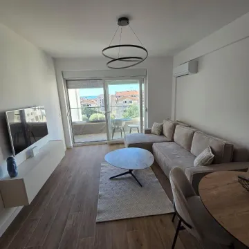 Living room with a sofa, coffee table and access to the terrace. - image 2