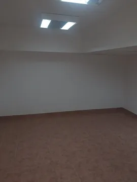 An empty room with tiled flooring and ceiling lighting. - image 2