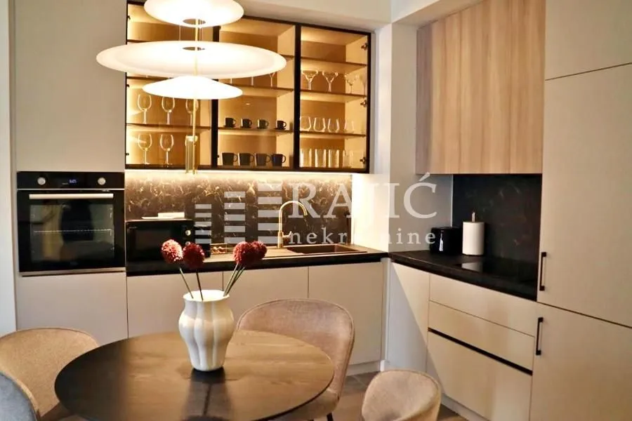 Modern kitchen with a dining table and built-in appliances.