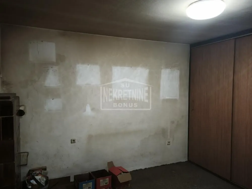 Pogled na dio prostorije sa ugradnim ormarom i kutijama na podu.