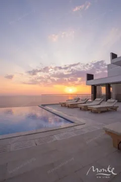 Terrace with a swimming pool and sun loungers overlooking the sea at sunset. - image 27