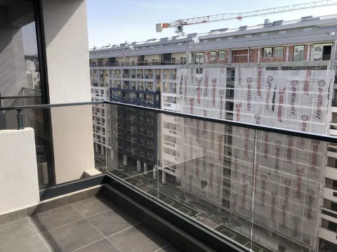 View from the balcony overlooking neighboring buildings and a construction site. - image 25
