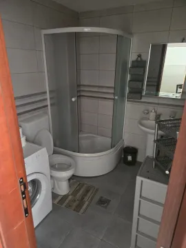 Manje opremljeno kupatilo sa tuš kabinom i veš mašinom. - image 3