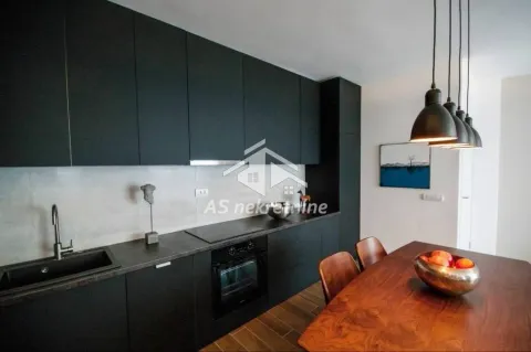 Modern black kitchen with a built-in oven and a dining table. - image 4