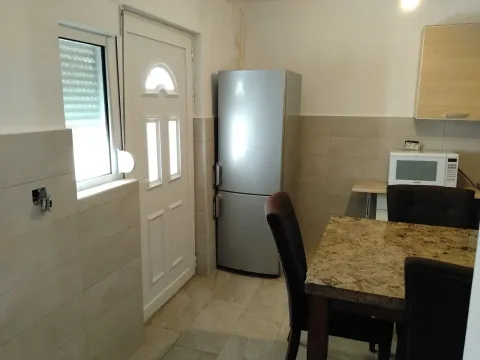 Small kitchen with a dining table and refrigerator. - image 3