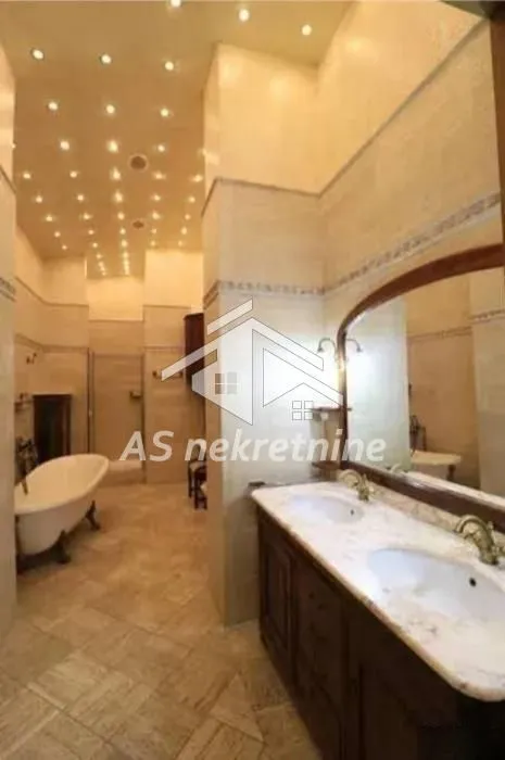Spacious bathroom with double vanity and bathtub.