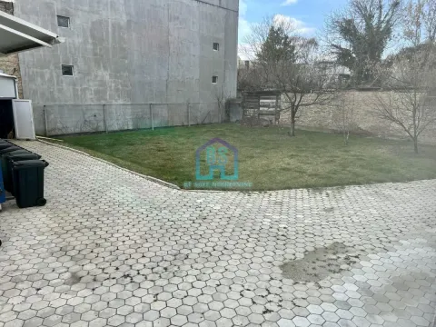 Yard with a lawn and a paved area in front of the building. - image 19
