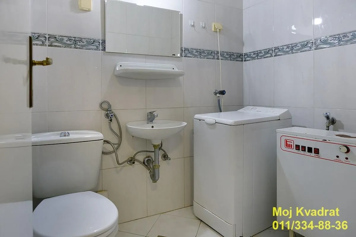 Kupatilo opremljeno sanitarijama i veš mašinom.