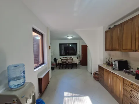 Kuhinja sa drvenim elementima i trpezarijom u pozadini. - image 2