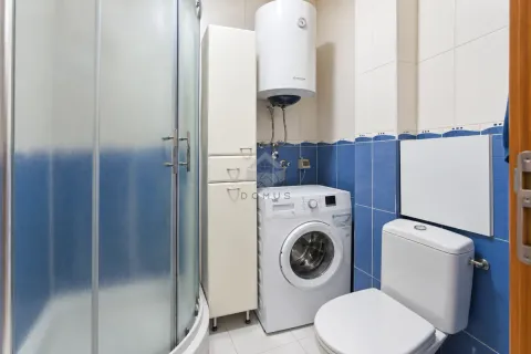 Bathroom with a shower cabin, washing machine, and water heater. - image 5