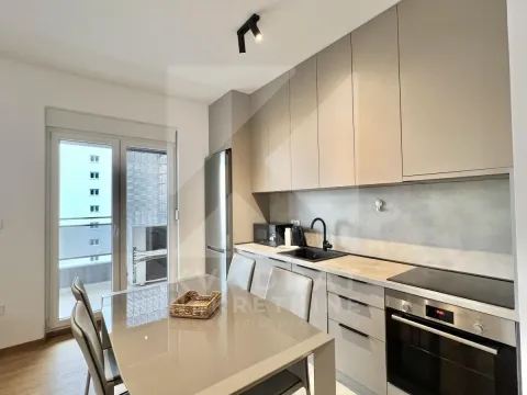 Modern kitchen with built-in appliances and a dining table. - image 11