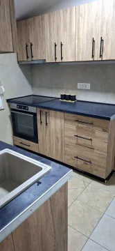 Modern kitchen with wooden cabinets and a black countertop. - image 9