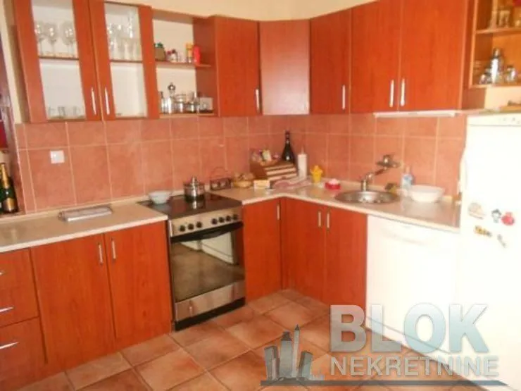 Kitchen with wooden cabinets, stove, and sink.