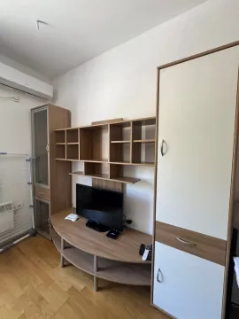 Living room with a TV and wooden furniture. - image 5