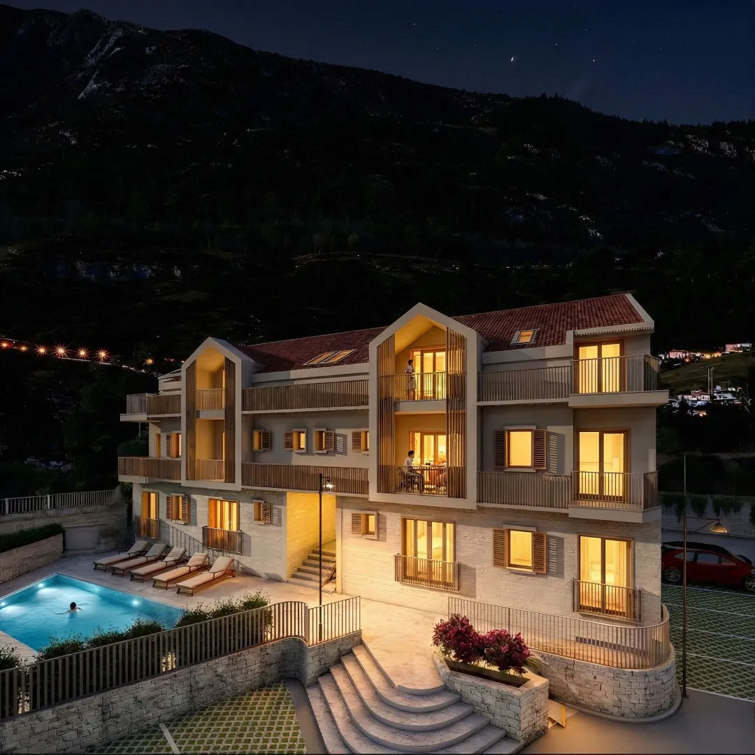 Night view of a modern apartment building with a swimming pool and illuminated terraces.