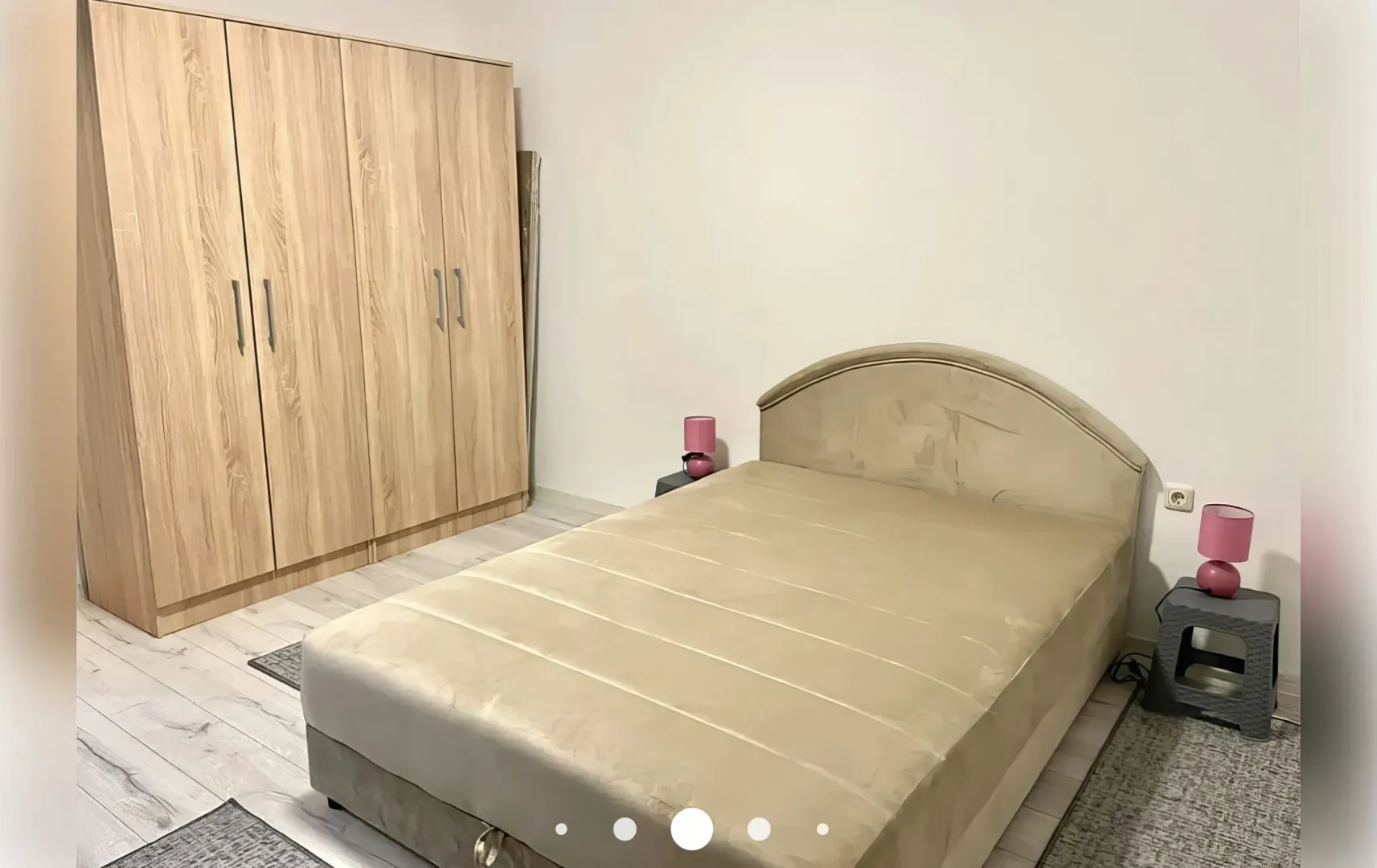 Namještena spavaća soba sa bračnim krevetom, garderoberom i noćnim stočićima.