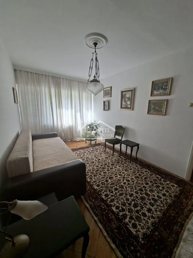 Living room with a sofa, rug, and paintings on the wall.
