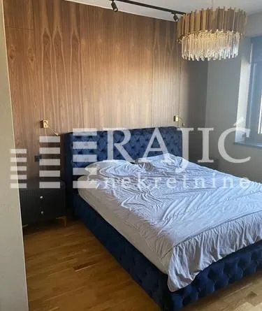 Modern bedroom with a double bed and wooden wall paneling.