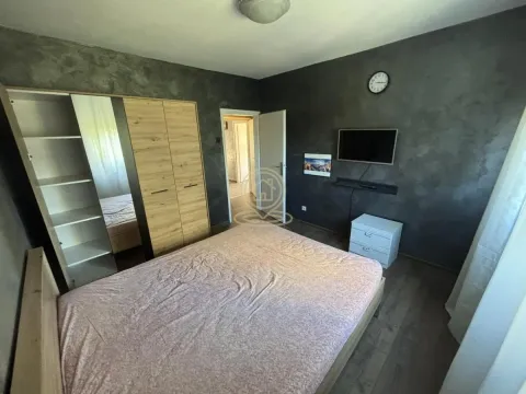Furnished bedroom with a double bed, wardrobe, and wall-mounted TV. - image 8