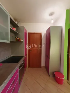 Smaller kitchen with pink elements and built-in appliances. - image 6