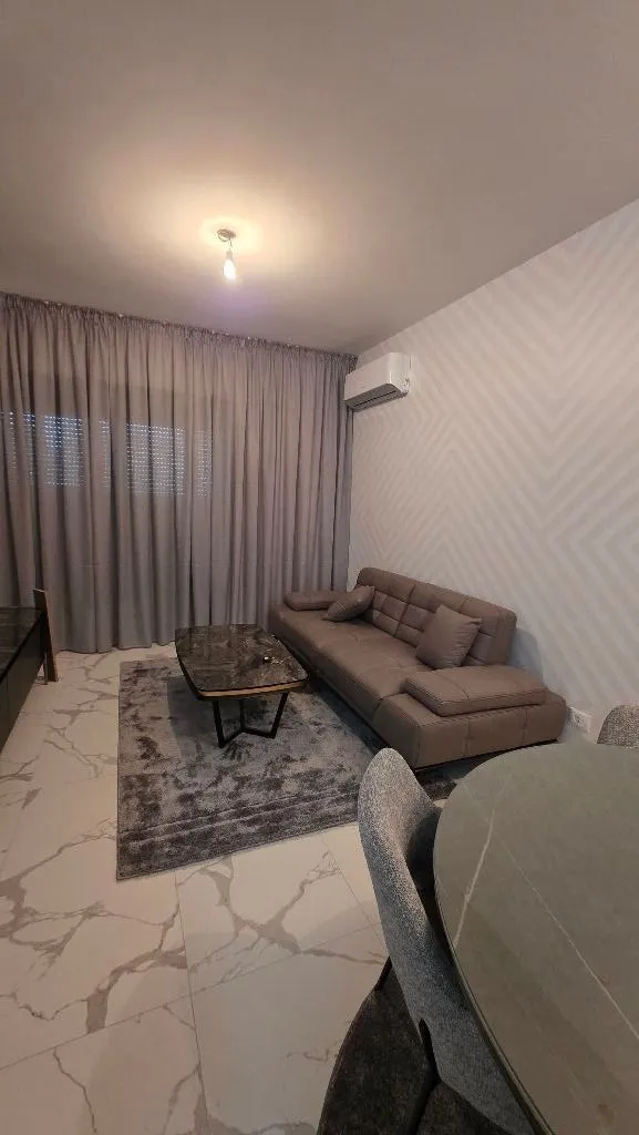 Living room with a sofa, coffee table, and dining table.