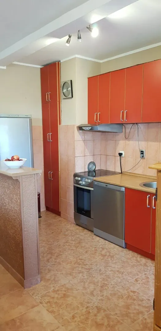 Kuhinja sa narandžastim elementima.