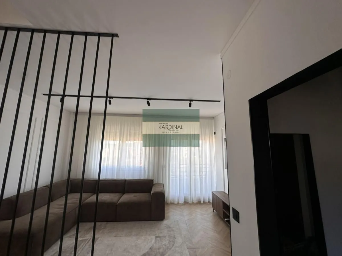 Pogled na dnevnu sobu sa garniturom i dekorativnom pregradom.