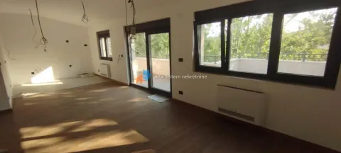 Prazna prostorija sa parketom i velikim prozorima koji vode na terasu. - image 2