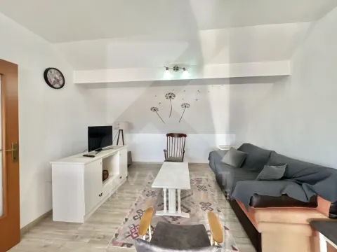Living room with sofa, TV, and dining table. - image 2