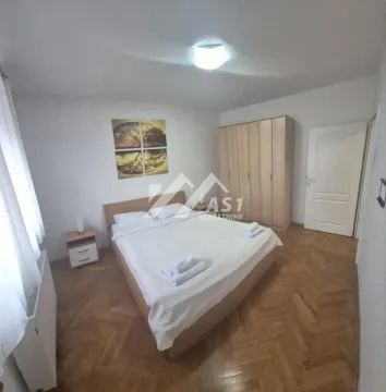 Nameštena spavaća soba sa bračnim krevetom, ormanom i drvenim podom. - image 6