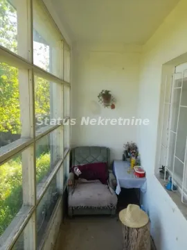 Zastakljena terasa sa foteljom i malim stolom. - image 13