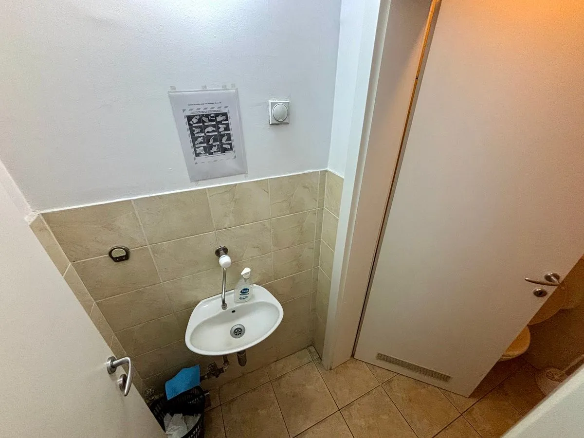 Small bathroom with a washbasin and wall tiles.
