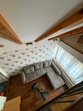 Pogled odozgo na dnevnu sobu sa garniturom i drvenim gredama na plafonu. - image 11