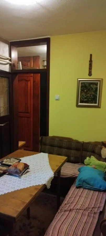 Manja trpezarija sa drvenom ugaonom garniturom i stolom.