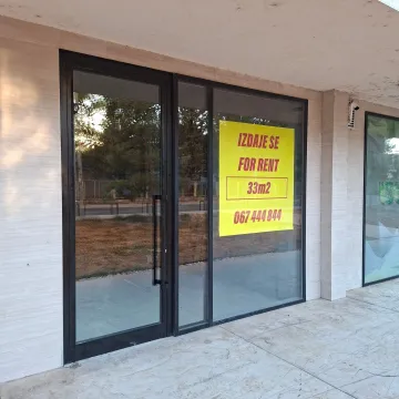 Facade of a commercial space with a glass shop window and a for rent sign. - image 2