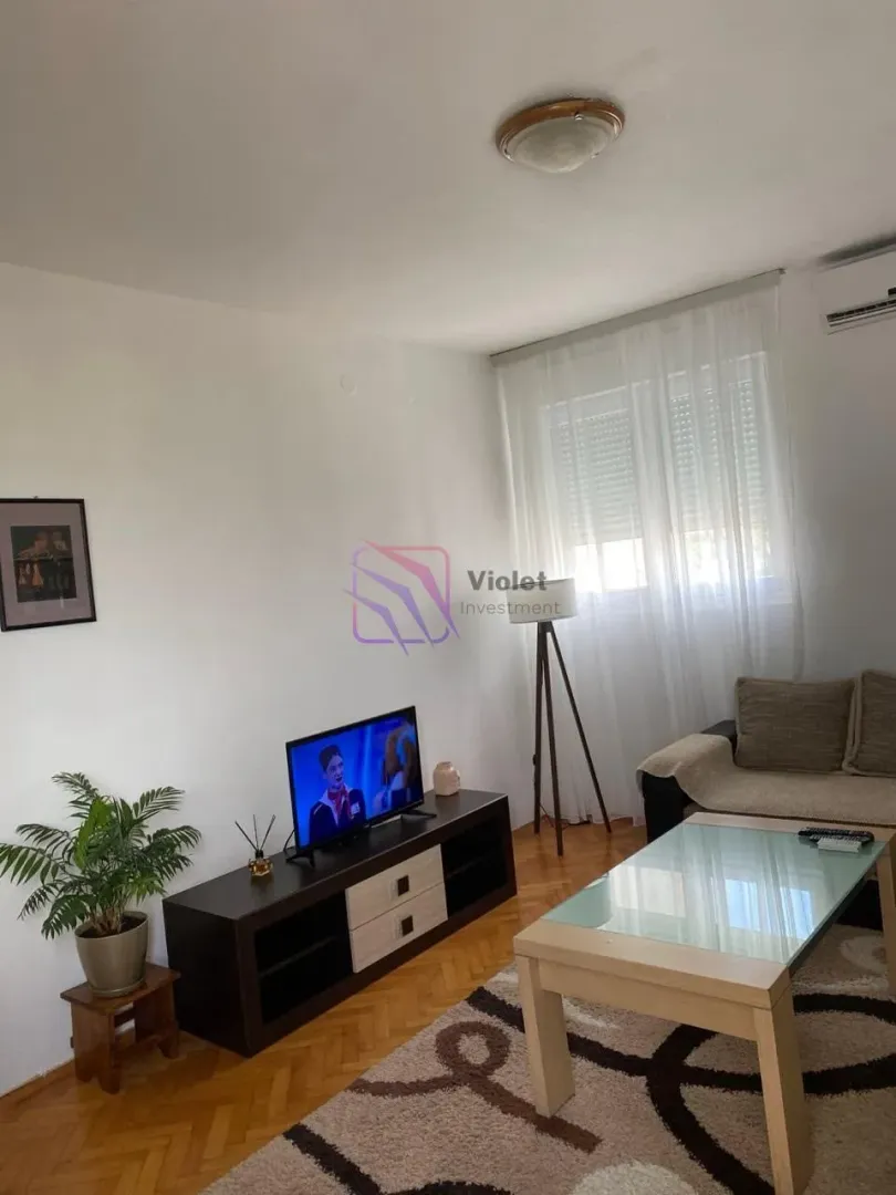 Dnevna soba sa garniturom, TV komodom i stočićem.