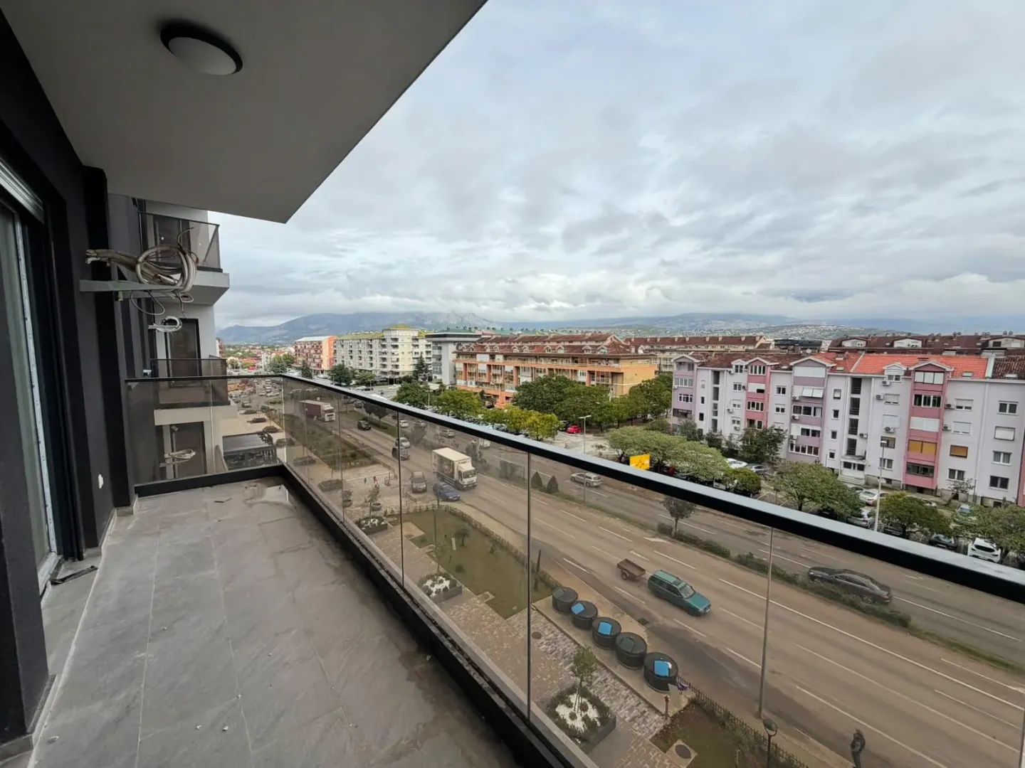 Prostrana terasa sa pogledom na ulicu i grad.