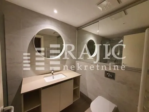 Modernly equipped bathroom with a washbasin and mirror.