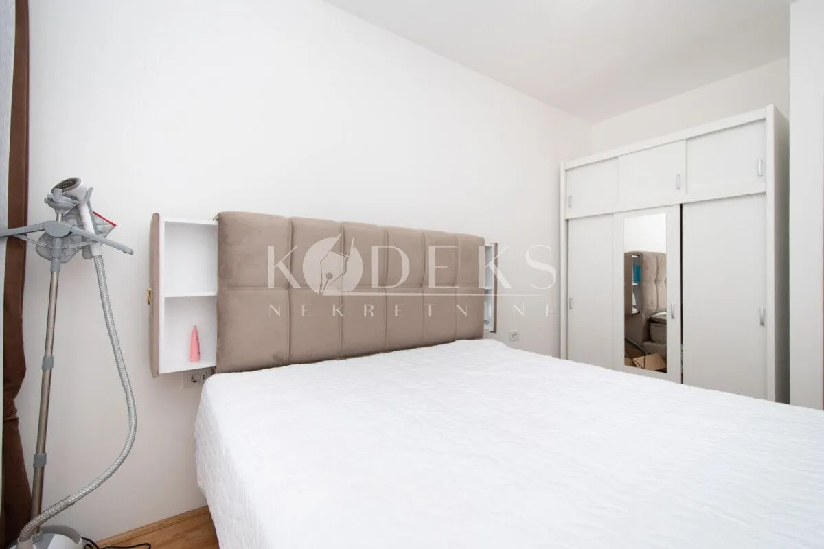 Bedroom with a double bed, upholstered headboard, and a white wardrobe.