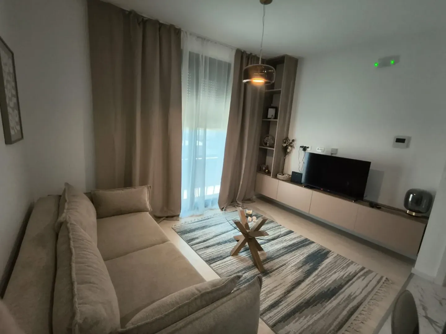 Uređena dnevna soba sa garniturom i televizorom.