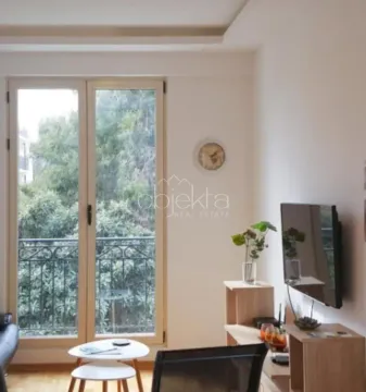 Dnevna soba sa televizorom, namještajem i izlazom na balkonska vrata. - image 11