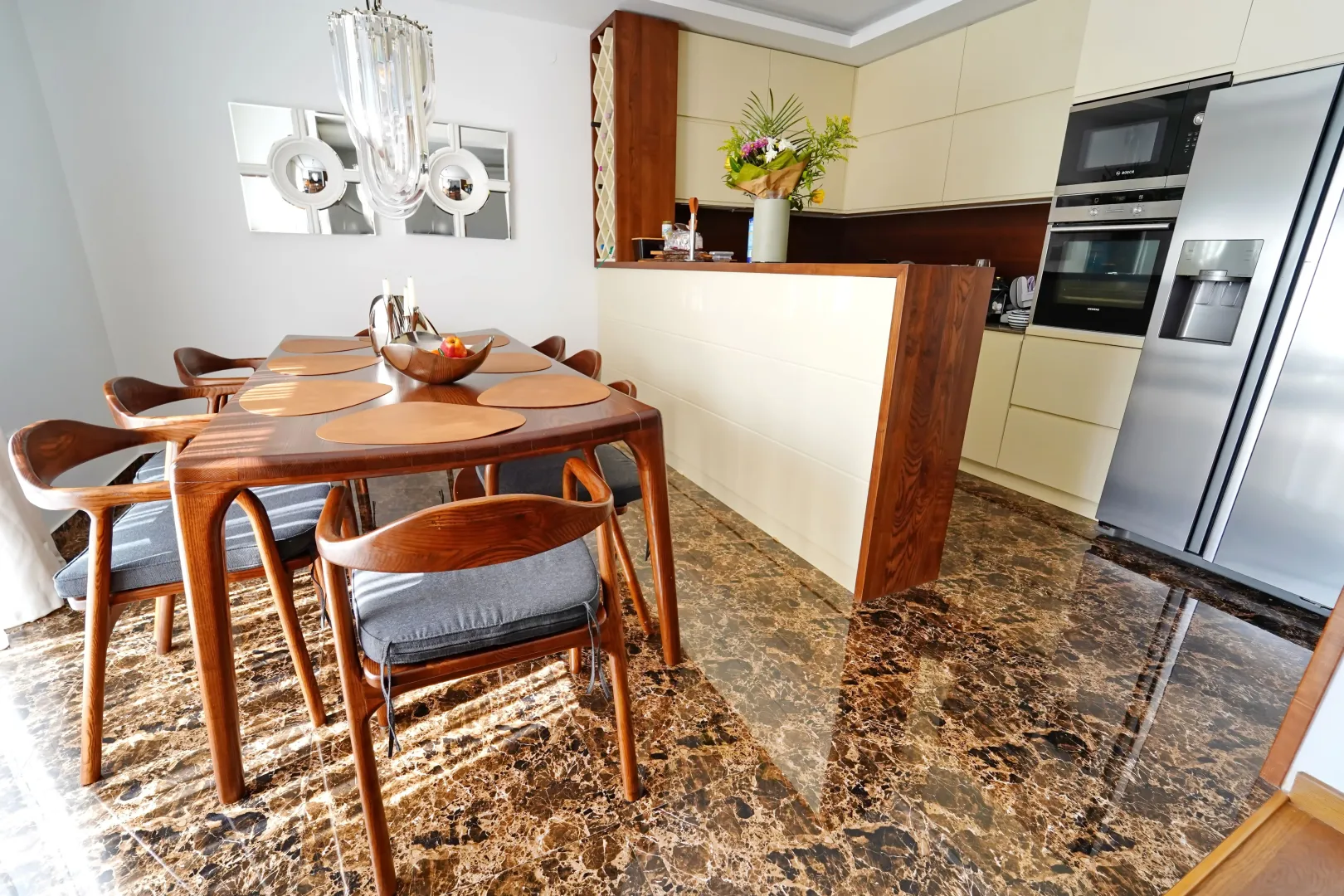 Modern kitchen with dining area and marble floor.