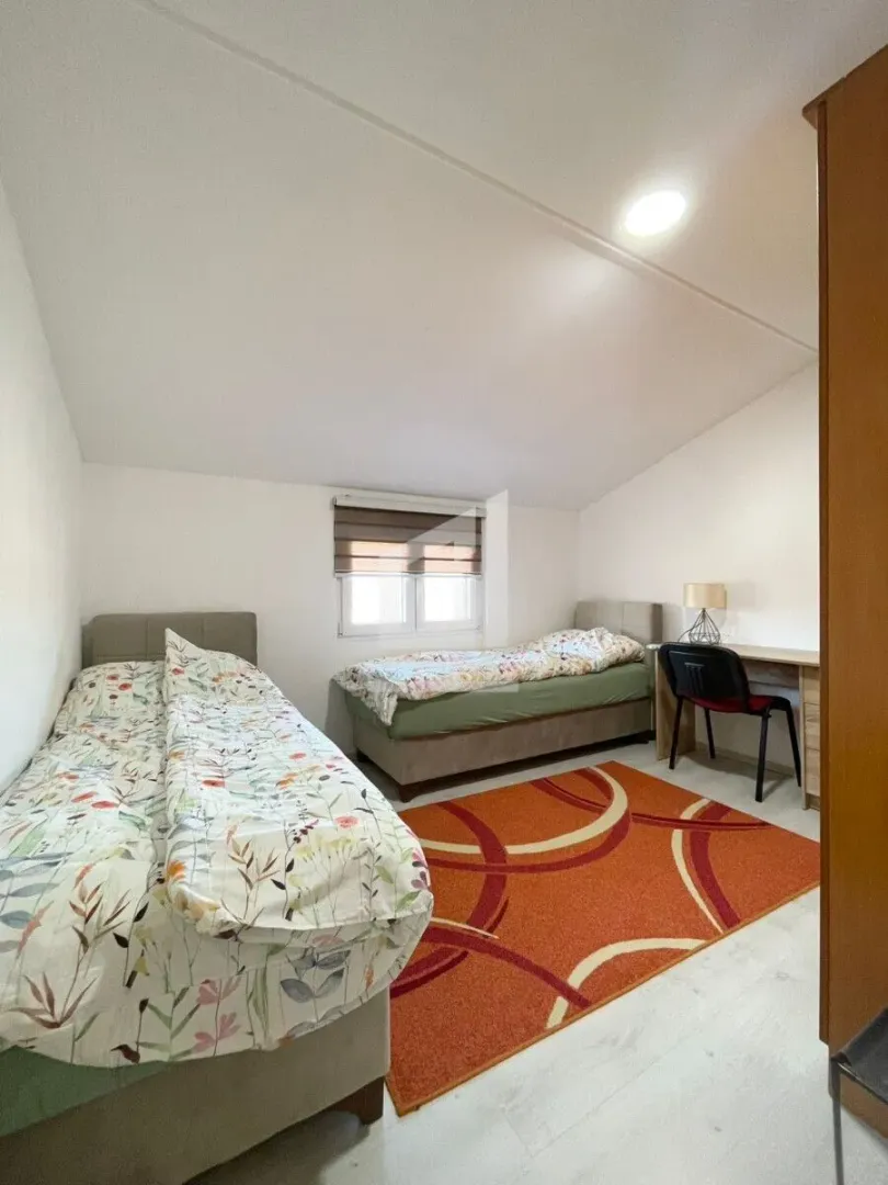 Bedroom with two beds and a desk.