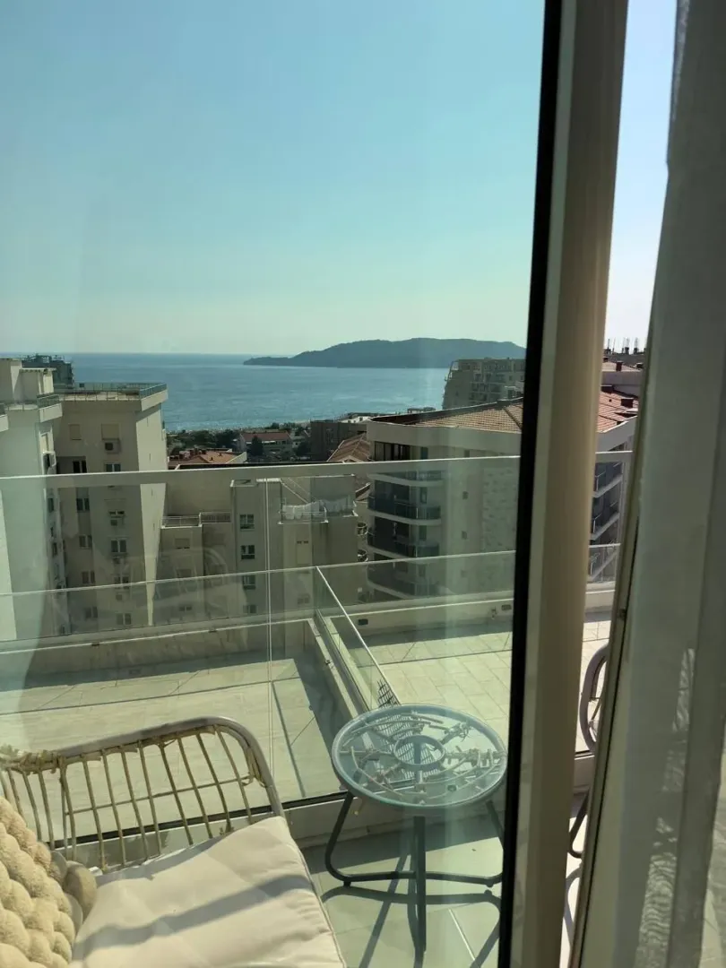 Furnished terrace with a view of the sea and surrounding buildings.